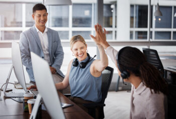 A group of people in an office setting high fiving