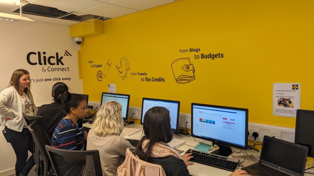 4 people sat at computers learning