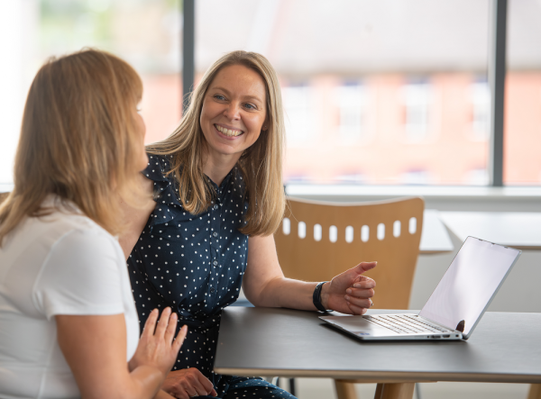 Two woman sat chatting over a table