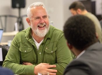 Man talking to another man smiling