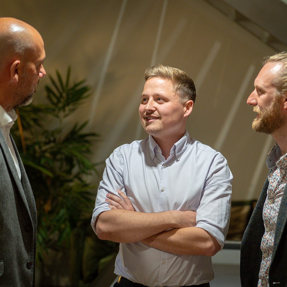 3 men chatting and smiling