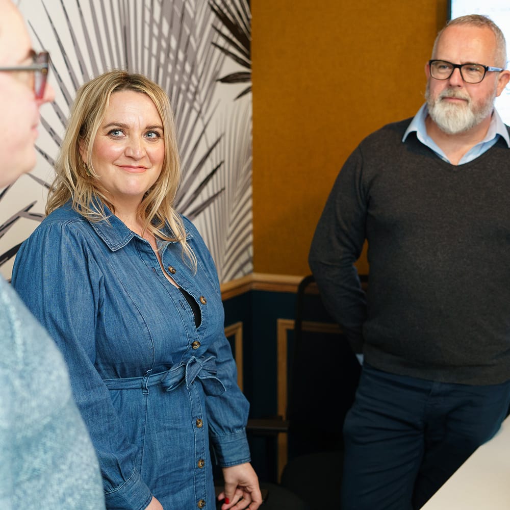 Two men and a woman stood chatting