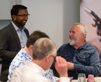Group of men around a table chatting
