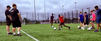 Children being coached playing football