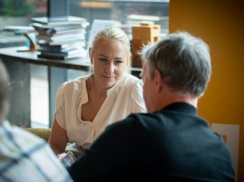 Woman talking to man sat at chairs